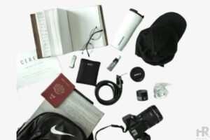 Travel essentials including  a camera, notebook, passport and accessories